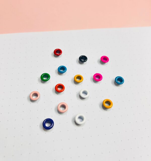 Eyelets 3/16” (.5cm ) Paq. 100 pzas  Mix de colores / Sirve para sujetar elástico en libretas